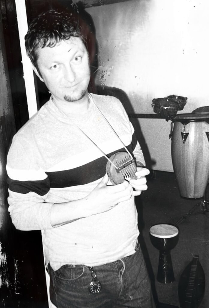 Dave Allen poses with a small thumb piano in his hands, at Eighth Dimension Studio in Orlando, Florida, 1998